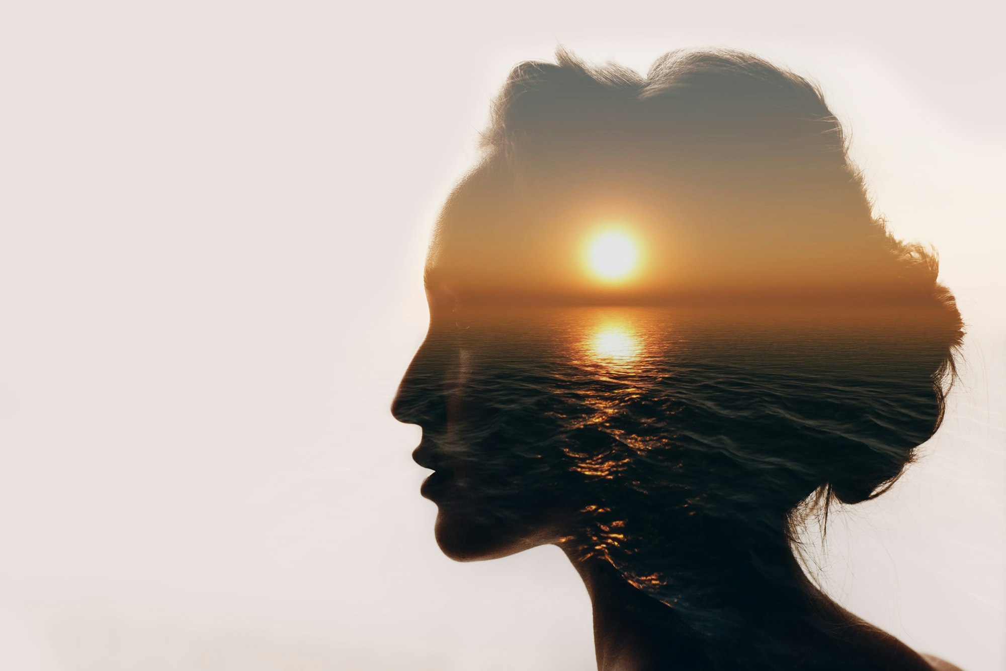 Multiple exposure sunrise and sea inside woman silhouette. Psychology concept